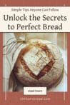 A rustic round loaf of homemade bread tied with twine, resting on parchment paper.