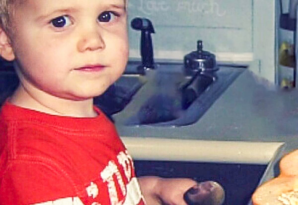 Close-up of my son helping in the kitchen, spoon in hand, as we worked on making pumpkin puree together.