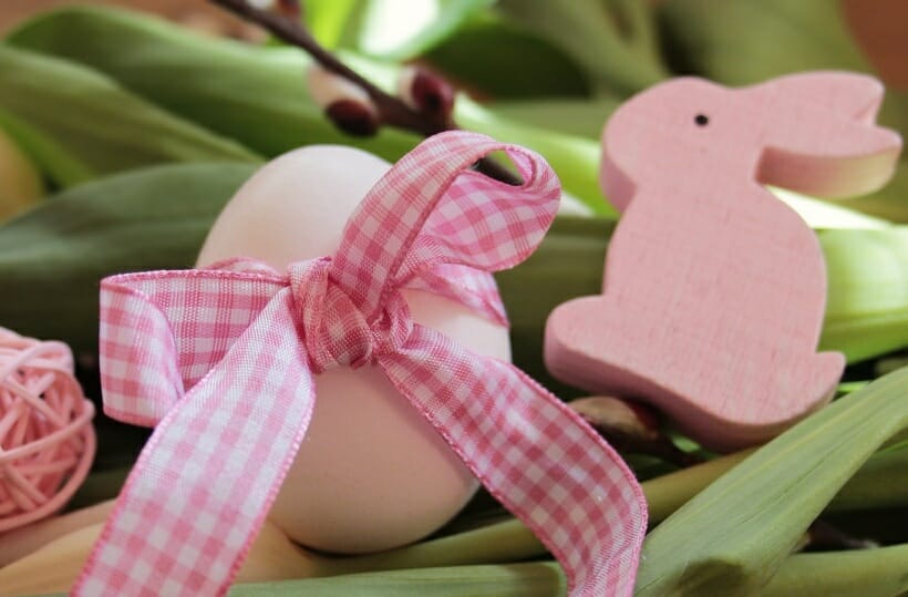 A pink easter egg with a pink gingham bow and a pink bunny peep.