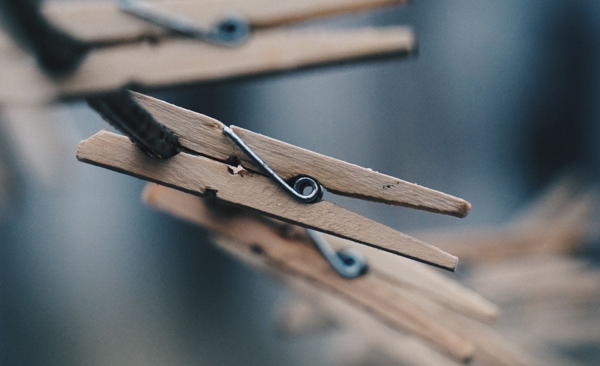 Wooden clothespins on a cotton clothesline.