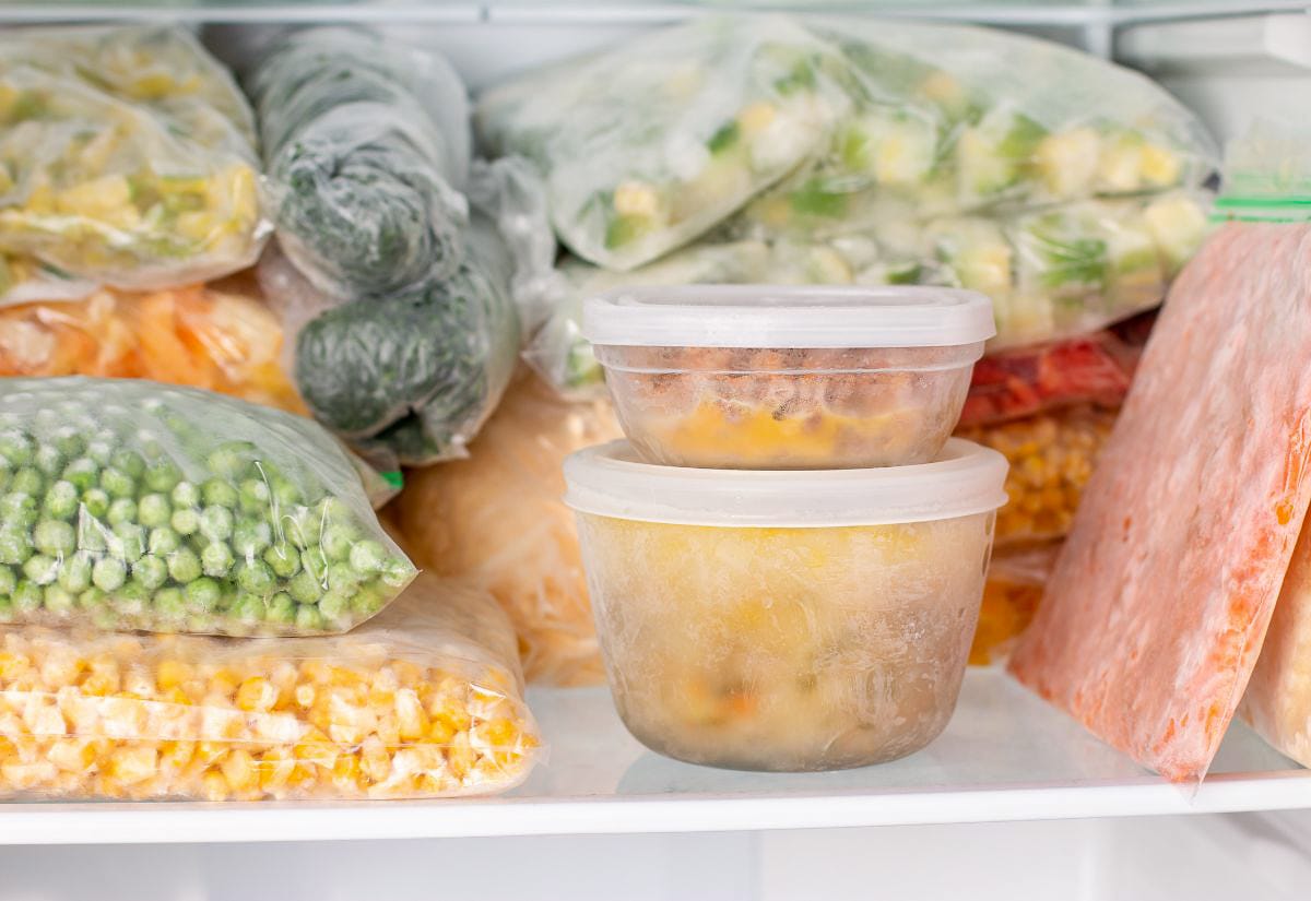 Organized freezer stocked with labeled bags and containers of frozen vegetables and homemade meals—representing food preservation and pantry management on the homestead.