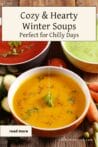 Three bowls of colorful winter soups—red tomato, yellow squash, and green pea soup—placed on a rustic wooden table with fresh vegetables nearby.