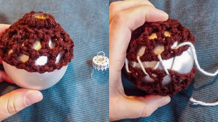 Hands holding a silver Christmas ball ornament while a brown crochet cover is stretched over the top, showing how the first crochet circle fits around the ornament cap opening.