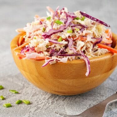 A wooden bowl of homemade coleslaw.