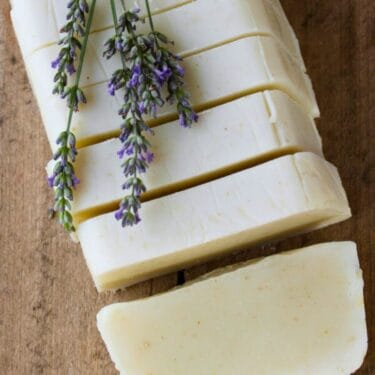 A cut loaf of goat milk shampoo bars with lavender on top.