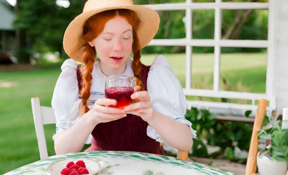 Anne of Green Gables enjoying a refreshing glass of raspberry cordial.