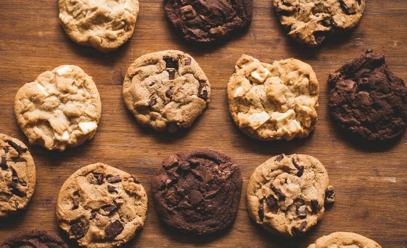 A variety of cookies laid out on a wooden tabletop.