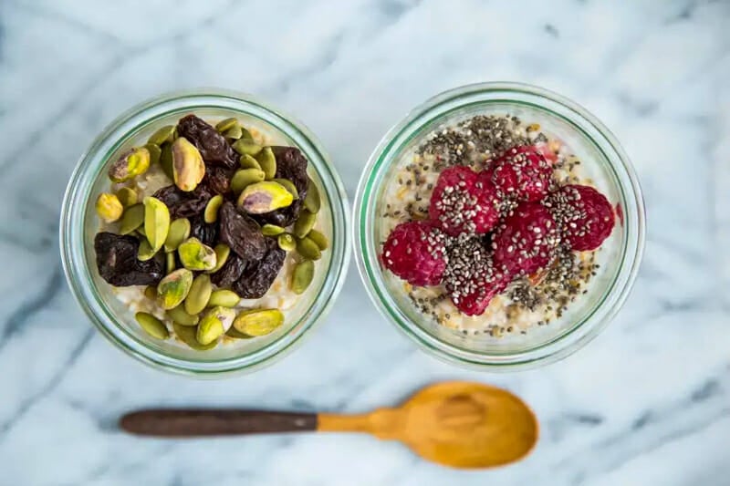 Steel cut oats and topped with fruits and nuts in mason jars.