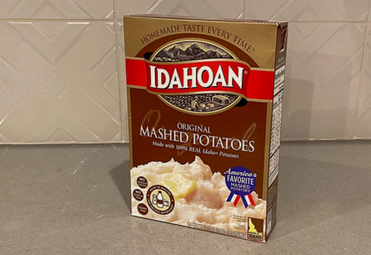 Box of Idahoan Original instant mashed potatoes on a kitchen counter, used as the base for making crispy potato pancakes.