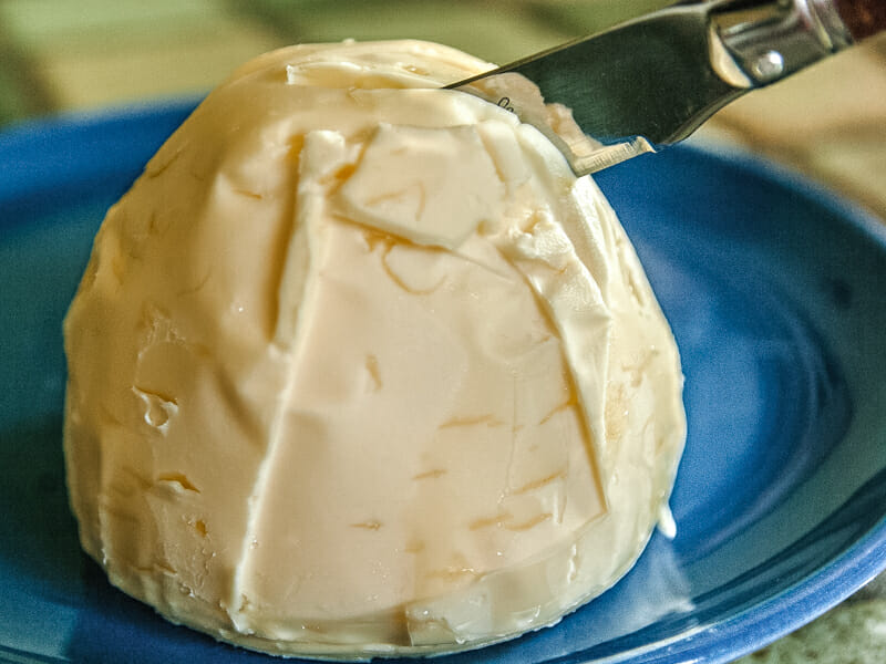Homemade butter on a blue plate.