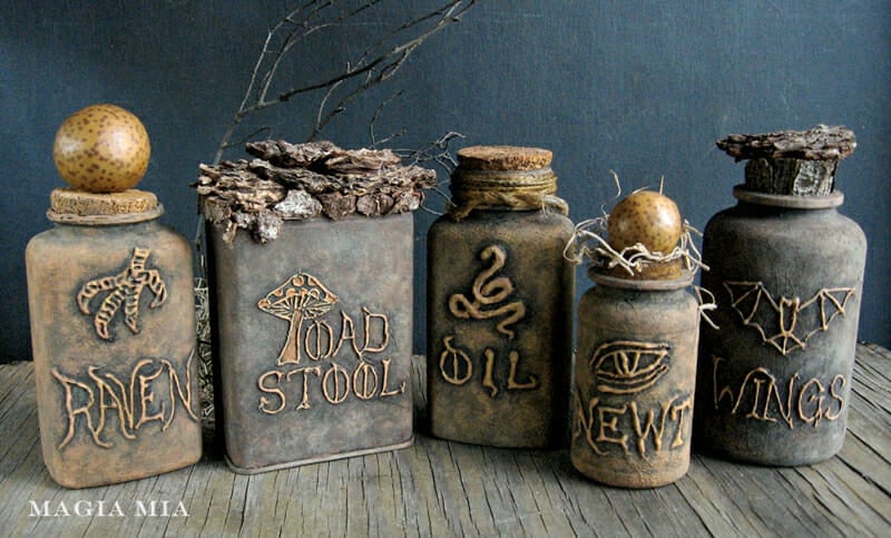 Medicine bottles decorated with paint and hot glue to look like a series of potion bottles.