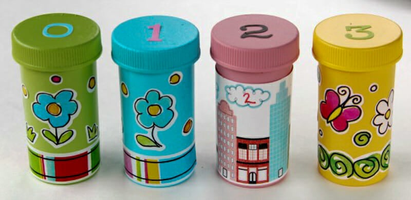 Painted pill bottles covered with stickers and the numbers 0-3 on top.