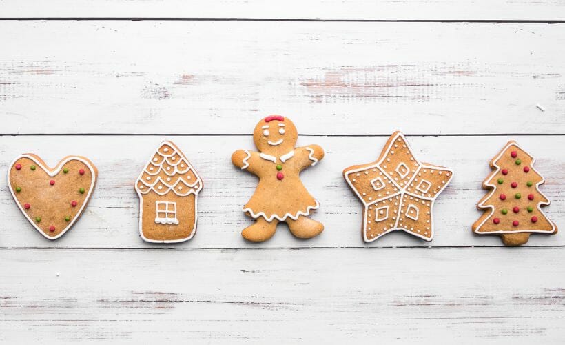 Christmas cookies lined up in a row on a wooden table.