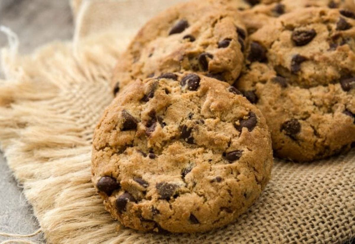 Thick homemade bacon chocolate chip cookies cooling on a piece of rustic burlap fabric.