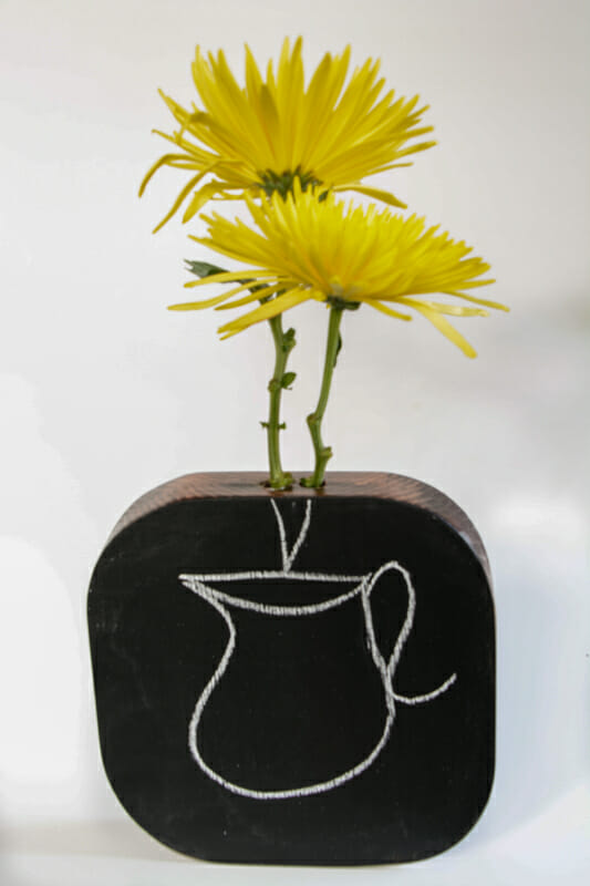 A wooden vase with chalkboard paint.