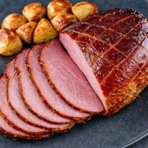 Glazed maple ham sliced and served with golden roasted potatoes.
