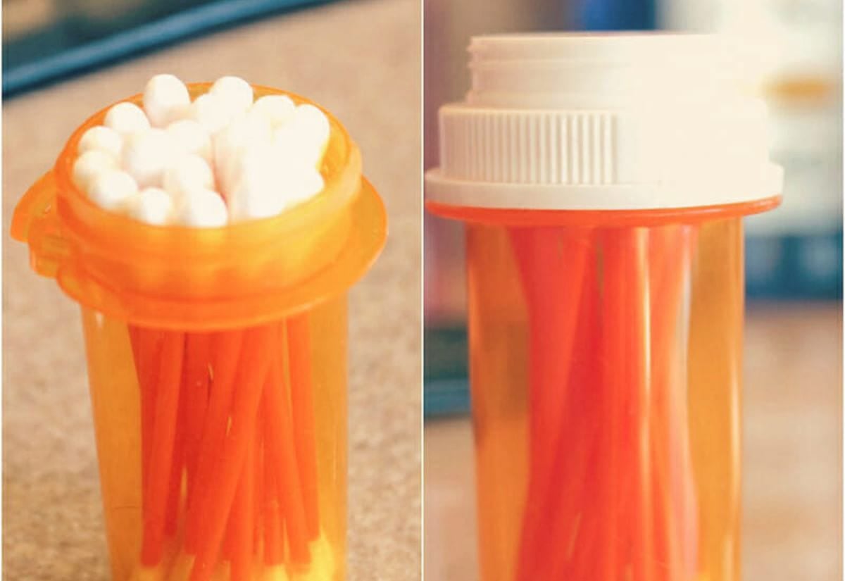 Prescription pill bottle filled with cotton swabs, shown with white lid on and off.