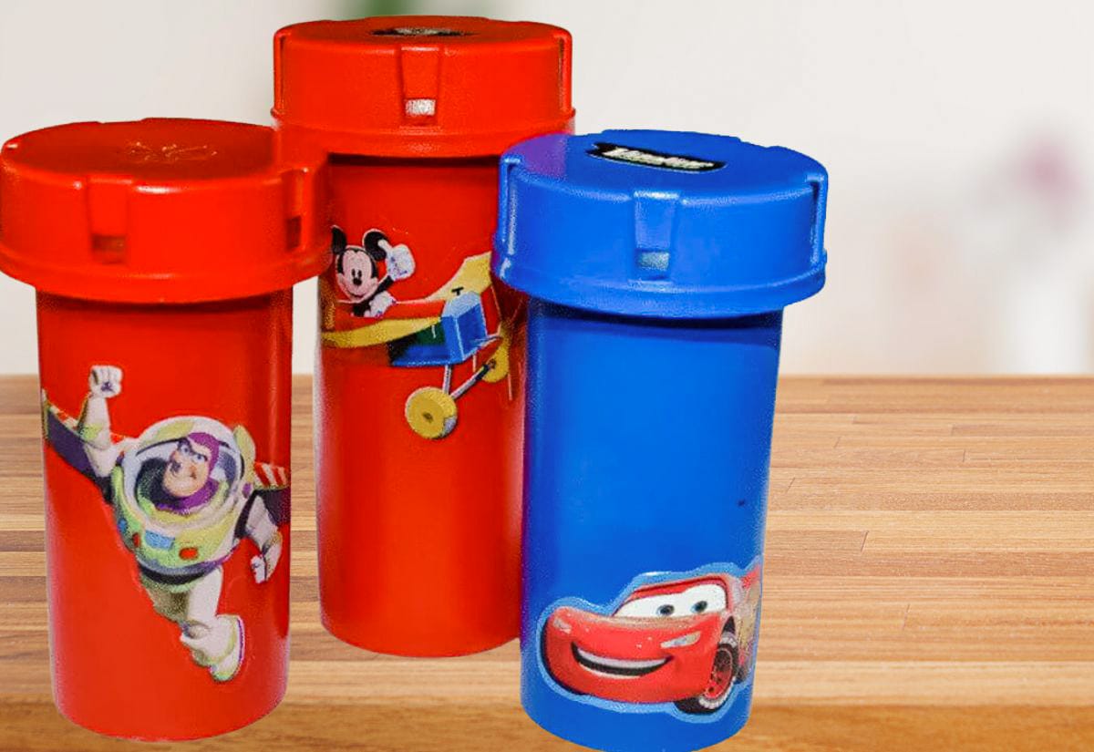 Red and blue pill bottles decorated with cartoon character stickers, used as fun coin storage containers for kids.