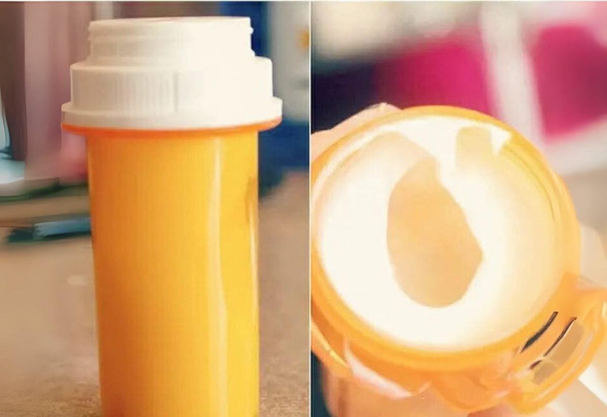 Orange prescription pill bottle with white cap shown as a travel-size container for shampoo, conditioner, or lotion.