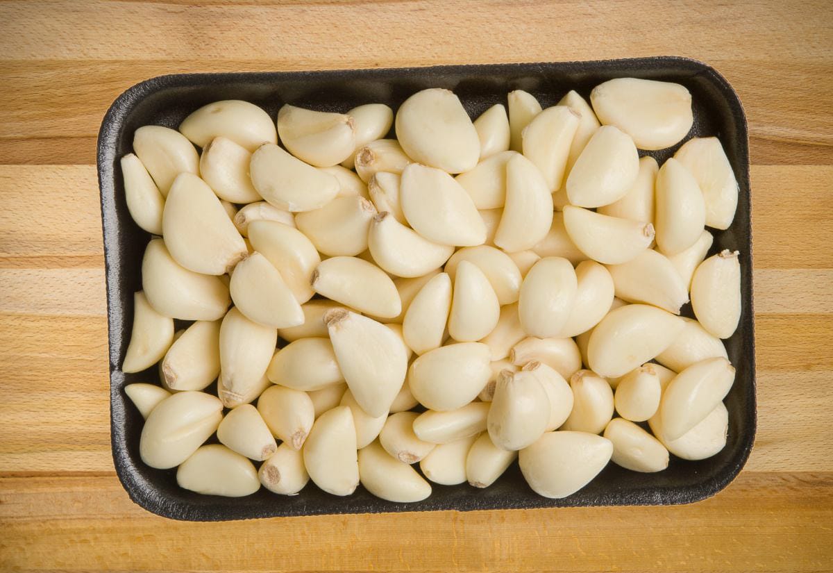 Tray of peeled garlic cloves ready to be frozen.