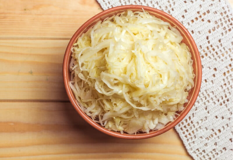 An orange bowl of homemade sauerkraut.