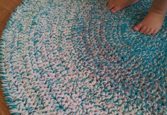 Baby feet on a homemade crochet round rug.
