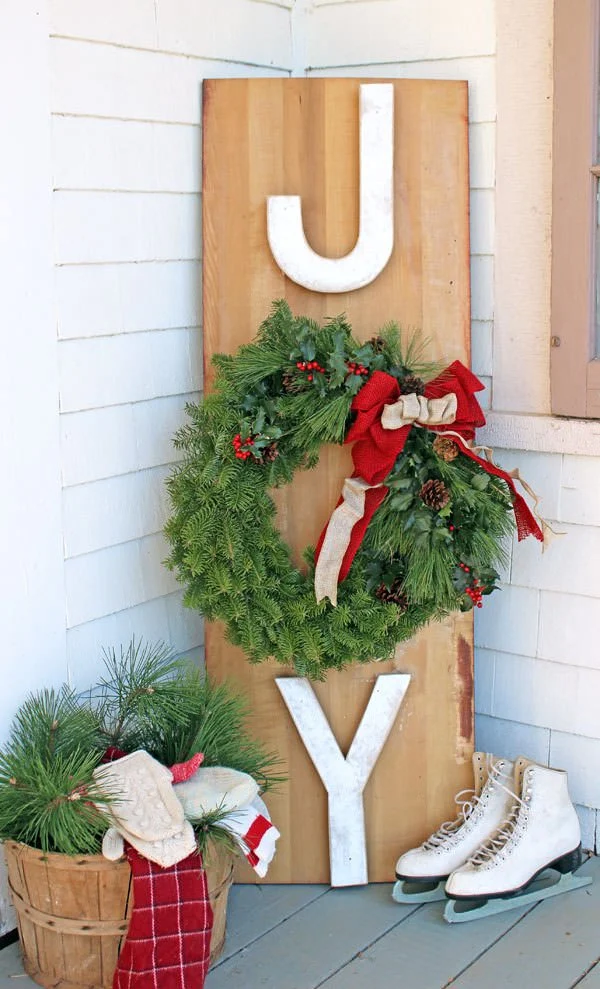 A holiday "joy" sign made of wood on the front porch.