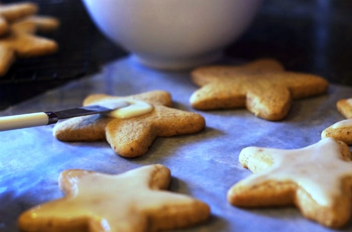Brushing icing on honey cut-out cookies.