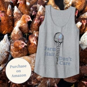 A gray Farm Hair, Don’t Care tank top displayed against a backdrop of brown chickens. The shirt features a detailed braid design with a feather accent, symbolizing a carefree farm lifestyle. A "Purchase on Amazon" badge is included, guiding customers to the product listing.