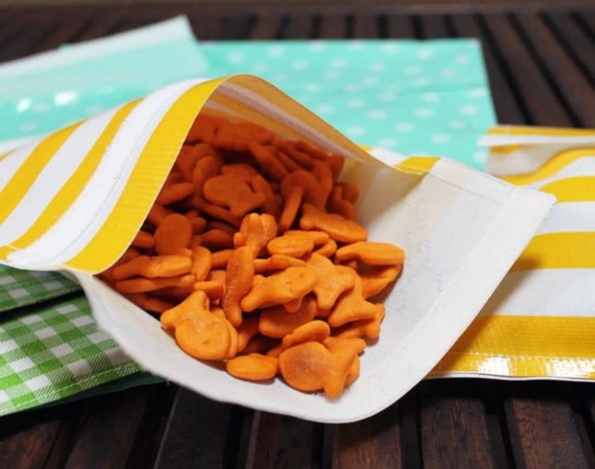 Multicolored reusable snack bags with goldfish crackers inside.