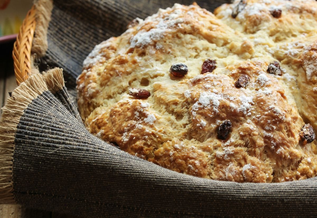 A warm Irish soda bread wrapped in a rustic linen cloth, fresh out of the oven.