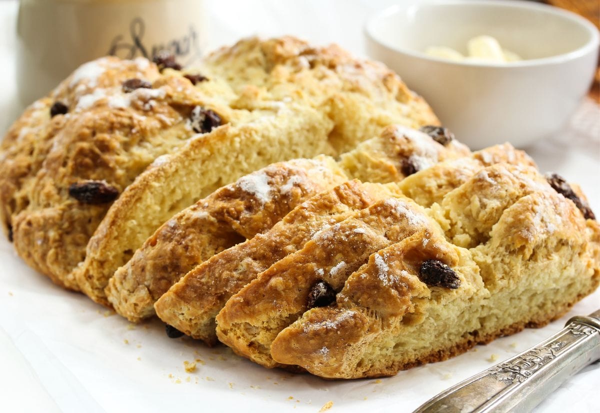 A sliced Irish soda bread showing its tender, crumbly interior with raisins throughout.