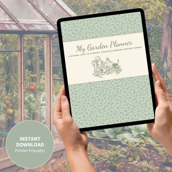 A lifestyle image featuring a tablet displaying the garden planner cover, held in hands in front of a greenhou