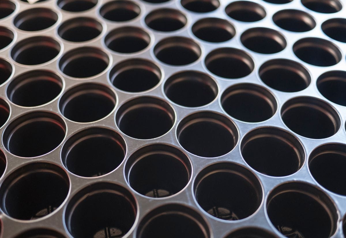 A close-up of a cleaned and dried seed tray with empty planting cells, prepared for seed starting.