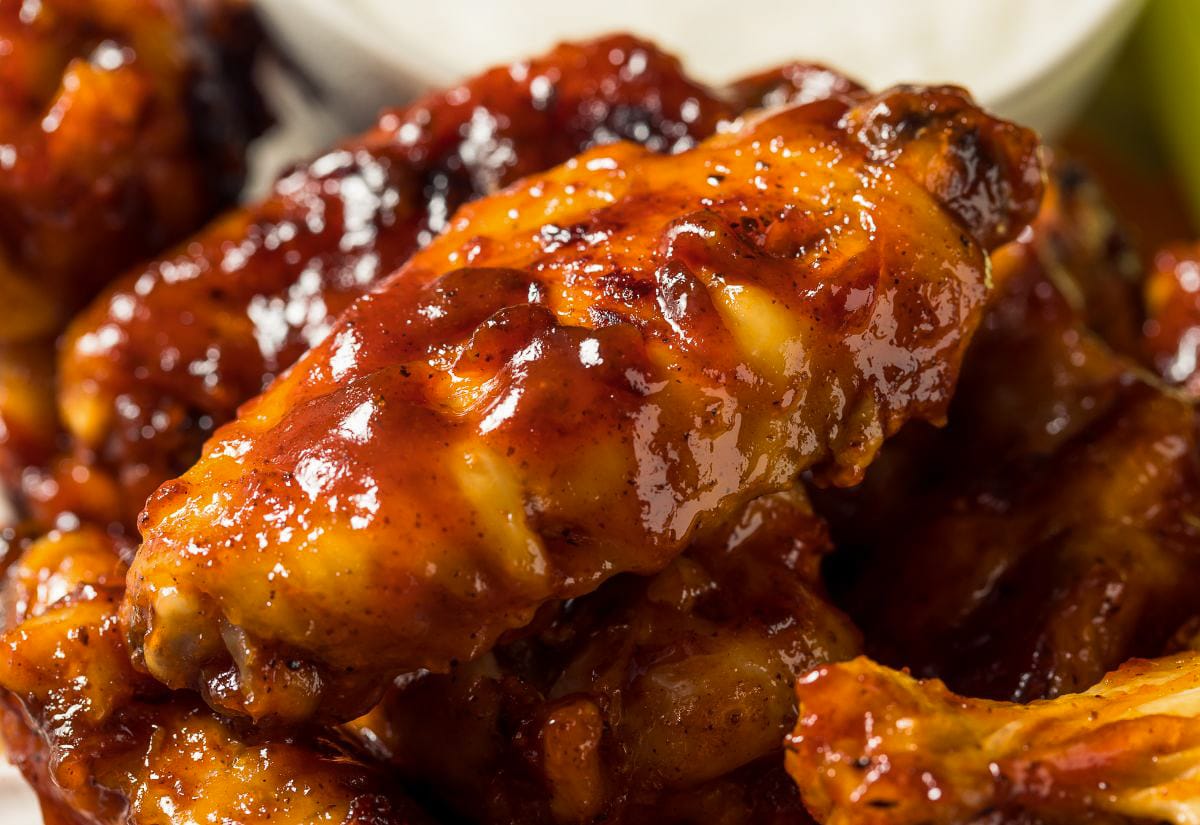 Close-up of barbecue chicken wings coated in a thick, glossy homemade BBQ sauce.