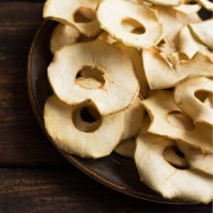 Close-up of dried apple rings with golden color and no browning, showing the finished result of dehydrating apples without browning.