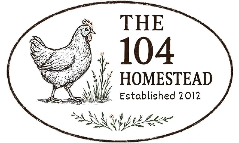 Hand-drawn logo for The 104 Homestead featuring a pencil-style illustration of a chicken standing beside sprigs of grass and small flowers, with the text “The 104 Homestead – Established 2012” in brown serif lettering inside an oval border.