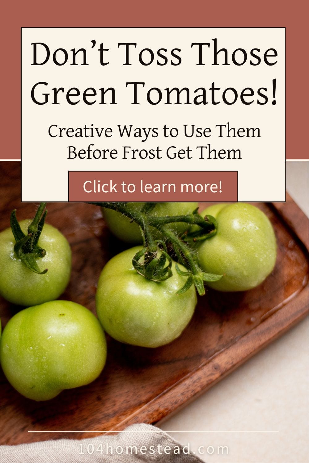 A wooden tray filled with freshly picked green tomatoes, still on the vine, sitting on a kitchen counter with a linen cloth nearby.